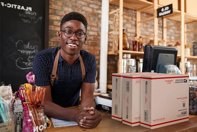 Small business owner with a stack of packages ready for shipment.